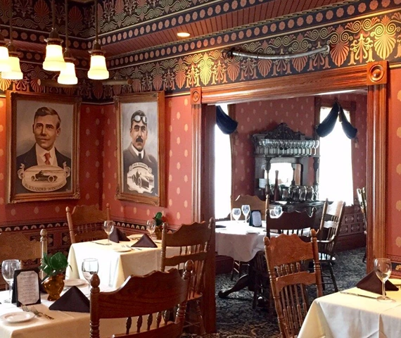 Rose Villa's historic dining room, with ornate woodwork and tables set for guests.